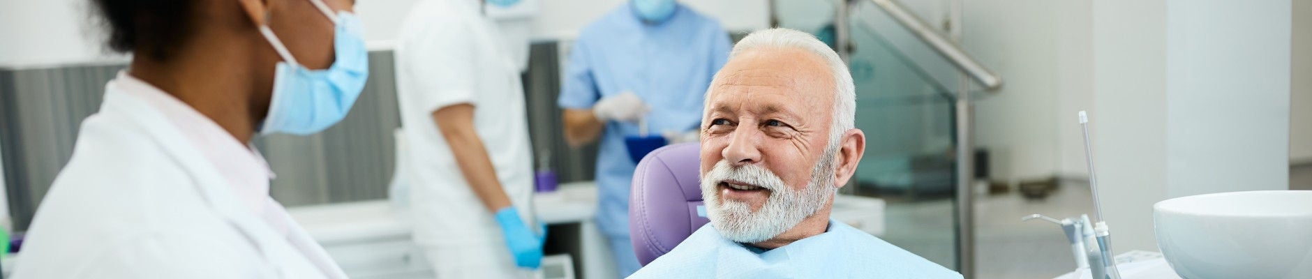 elderly man speaking with dentist