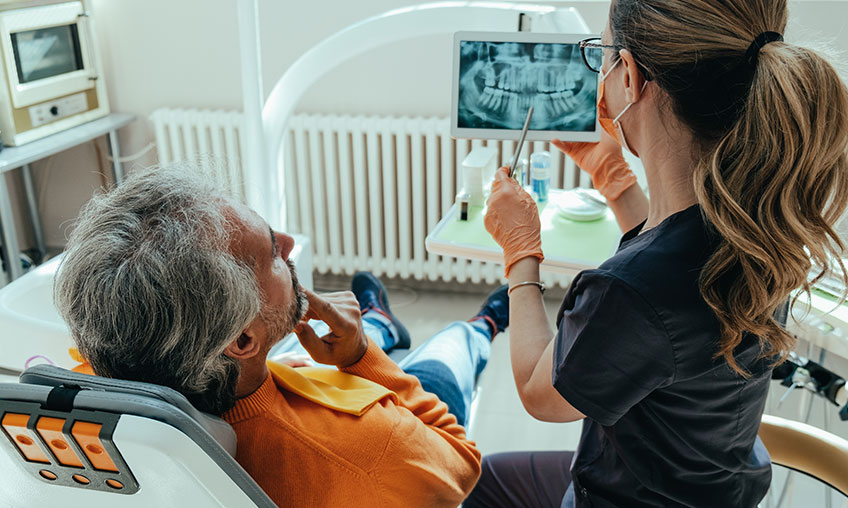 dentist showing patient xrays in dental chair