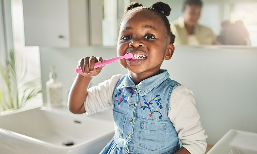young girl brushing teeth