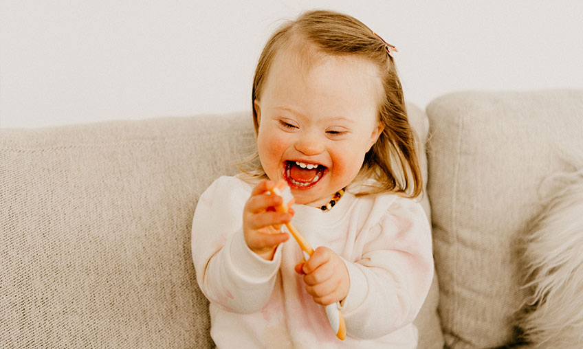 child with disability playing with toothbrush