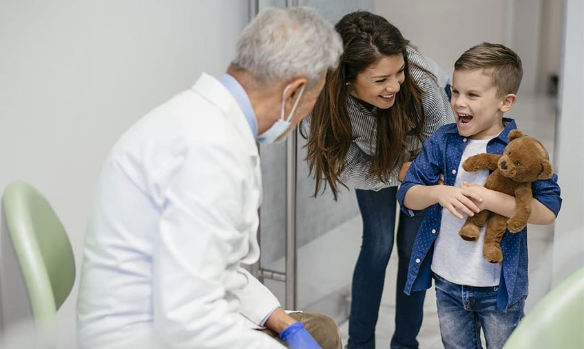 child with teddy bear meeting the dentist