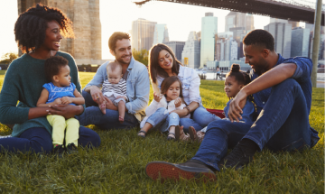 Familias sentadas juntas en un parque público