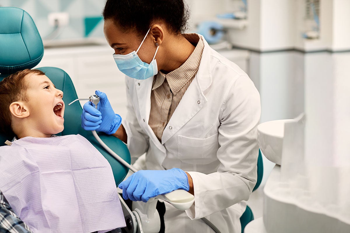 Dental provider during a teeth cleaning session Dental provider during a teeth cleaning session