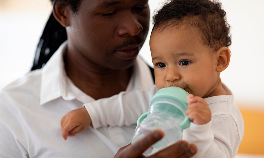 baby drinking water from sippy cup